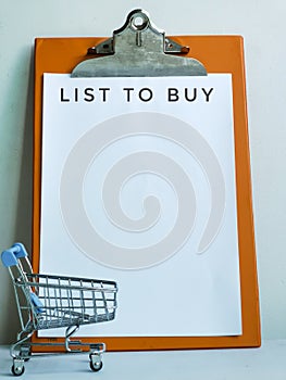 Phrase list to buy with trolley and clipboard on the table.