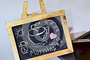 Phrase morning love written on a chalkboard on it and smartphone, laptop