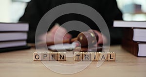 Phrase Open Trial and judge in robe and gavel on sound block
