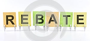 The phrase REBATE is written on multi-colored stickers, on the white background. Business concept, strategy, planning