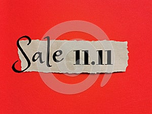 Phrase Sale 11.11 on a torn brown paper isolated on red background.
