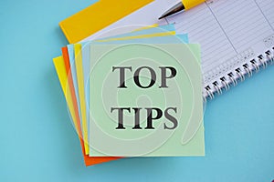 The phrase Top Tips text on sticker note as a reminder, Business concept,blue background