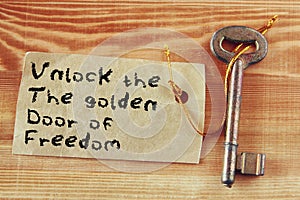 The phrase - unlock the golden door of freedom written on note attached to key