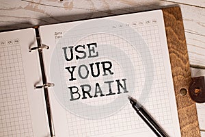 The phrase Use Your Brain in blue text on an index card pinned to a cork notice board as a reminder