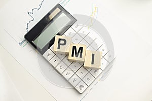 Phrase or word - pmi. Wooden block letter word and modern calculator on a yellow background, business concept with space for text