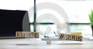 Phrases Life and Work placed on wooden scales on table
