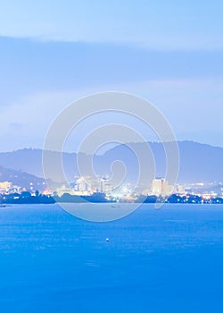 Phuket Island at twilight. Beautiful modern city with light, mountains and sunset sky backgrounds, twilight reflecting in the sea