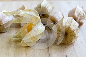 Physalis peruviana orange ripened fruits in husk on wooden table