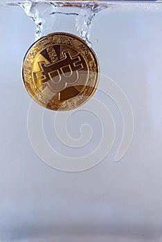 Physical bitcoin dropped in water photo