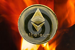 Physical Ethereum gold coin ETH with fire or flame background