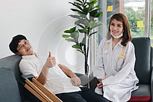 Physical female doctor helping patient with crutches in hospital office