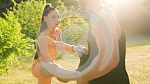 Physical Fitness Personal Trainer Assists Male and Female Athletes Outdoors