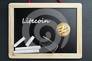Physical Litecoin gold coin on a blackboard with chalk