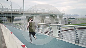 Physical, sportive exercising across the footbridge and urban town