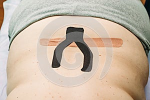 Physical therapist applying elastic therapeutic tape or kinesiology tape kinesio tape