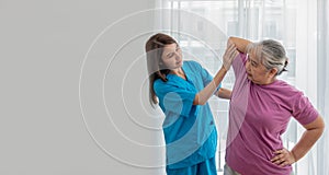 Physical therapist Asian woman, doing arm physiotherapy for elderly woman