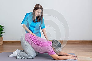 Physical therapist Asian woman, doing back and lumbar physiotherapy for elderly woman