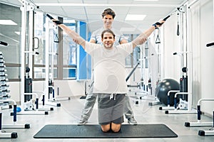 Physical therapist assisting a patient while exercising on hyperextension