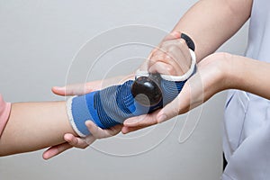 Physical therapist assisting patient woman in lifting dumbbells