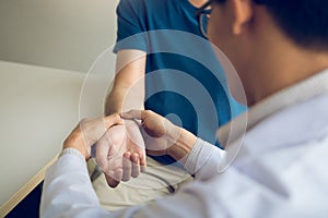 Physical therapist checks the patient wrist by pressing the wrist bone in clinic room