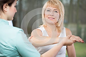 Physical therapist diagnosing painful arm