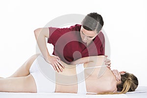 Physical therapist makes spinal mobilization to woman