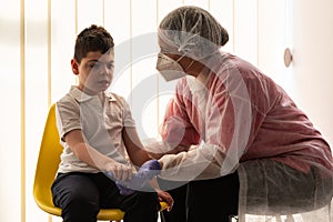 A physical therapist or nurse is talking to and caring for a young child with multiple disabilities in the clinic, rehabilitation photo