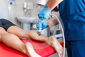 Physical therapy of the shin with shock wave, extracorporeal shockwave therapy.