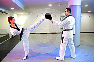 Physically challenged young woman in taekwondo practicing a high kick