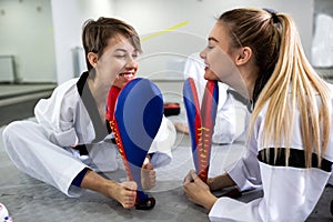 Physically disabled martial art combat fighter and her friend holding a kick pad target photo