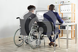 Physically Impaired Businessman With His Partner Working