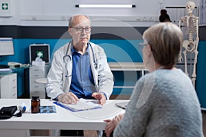 Physician attending consultation appointment with aged patient in office
