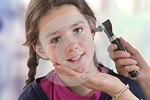 ENT physician checking patient`s ear using otoscope photo