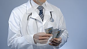 Physician counting bundle of money, expensive medicine at private clinic, bribe