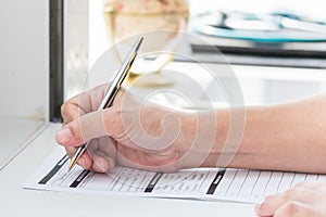 Physician doctor writing on medical health care record, patients discharge, or prescription form paperwork in hospital clinic