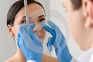 Physician examining face of serene female
