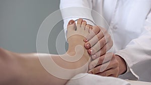 Physician examining patient foot, assessment of injury severity, healthcare