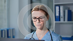 Physician feels a sore throat while working in hospital, medical worker in glasses wearing blue uniform touches neck