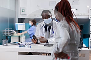 Physician giving bottle of pills to pregnant woman with sickness