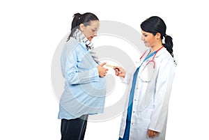 Physician giving pills to pregnant