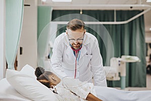 Physician listening to the heart beat of a little girl