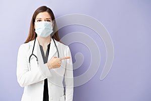 Physician with mask pointing at copy space