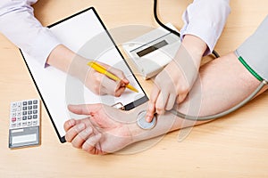 Physician measures blood pulse of patient