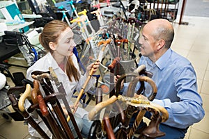 Physician offering cane to customer