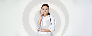 Physician-patient privilege, medical confidentiality. Asian woman doctor showing silence, mouth zip gesture, secret