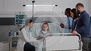 Physician pediatric doctor monitoring disease symptoms while african american nurse checking IV drip bag