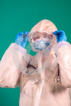 The physician puts on a PPE suit uniform with a stethoscope on the shoulder, wearing a medical protective Mask and glasses on the