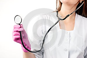 Physician with stethoscope hold in pink gloves ready to check patient, fragment