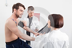 Physician taking a male patients blood pressure