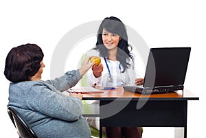 Physician woman offering apple to elderly